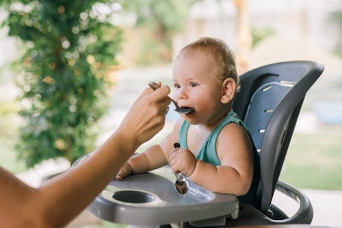 parent encouraging toddler to eat