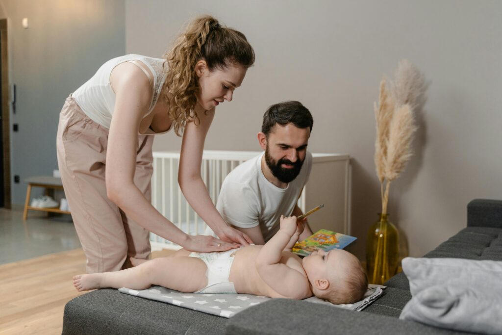 parent gently changing toddler diaper during daily routine